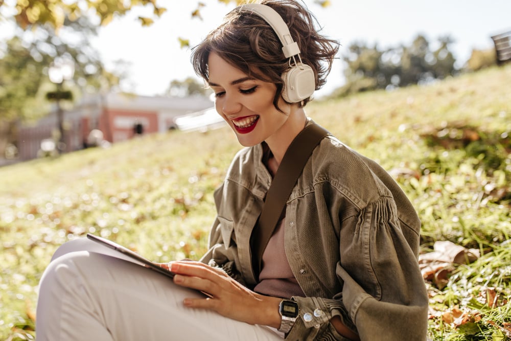 woman reading a book with headphones - Free Speechify Alternative