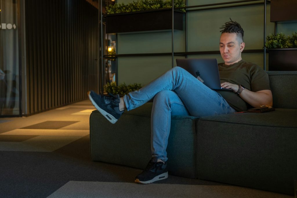 man using a macbook - Examples of Conversational AI 
