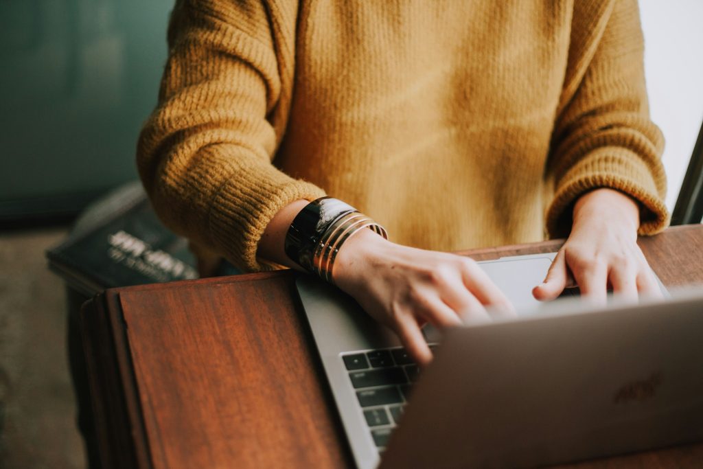 woman typing on a laptop - How to Make Text-to-Speech Sound Less Robotic