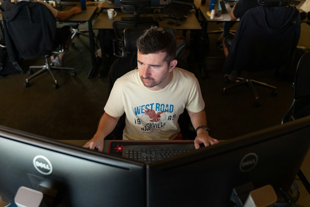 man working on desktop wearing a white tshirt - Conversational AI Examples
