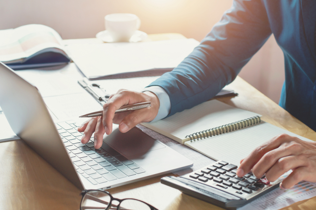 man using calculator - Call Center Cost Per Call
