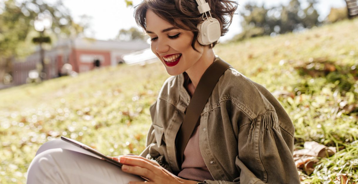 woman reading a book with headphones - Free Speechify Alternative
