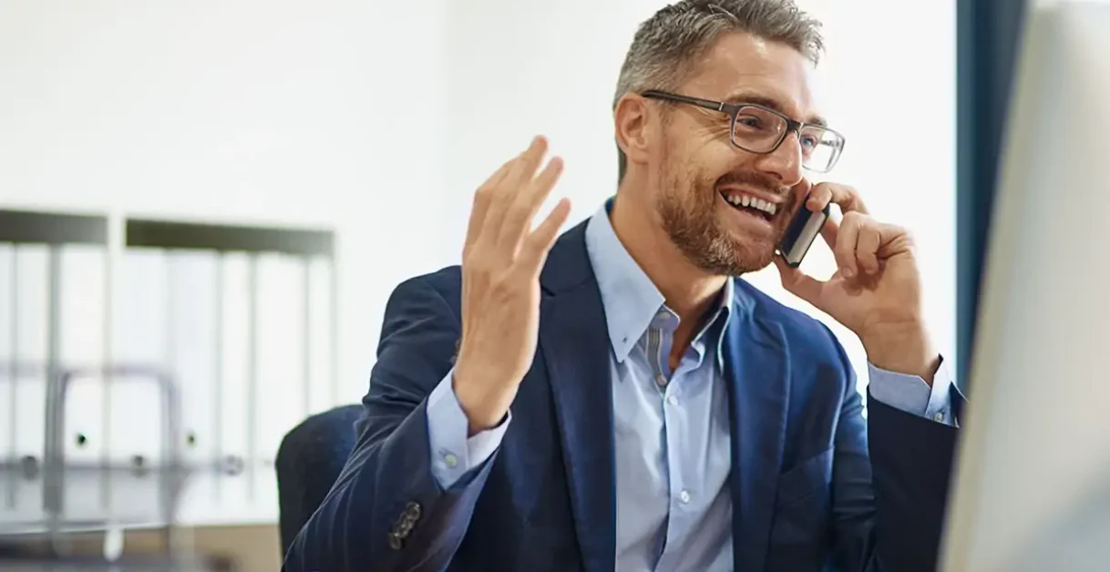 man smiling and talking on a phone - CloudTalk Alternatives